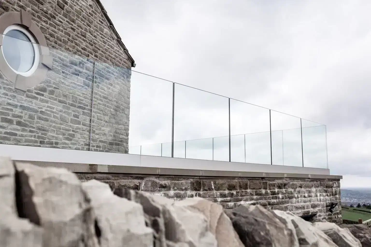 Garde-corps en verre sans montant sur une terrasse en pierre
